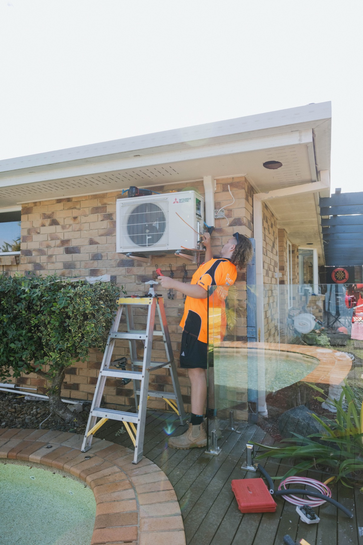 Mitsubishi Electric outdoor unit installed on wall bracket on brick exterior