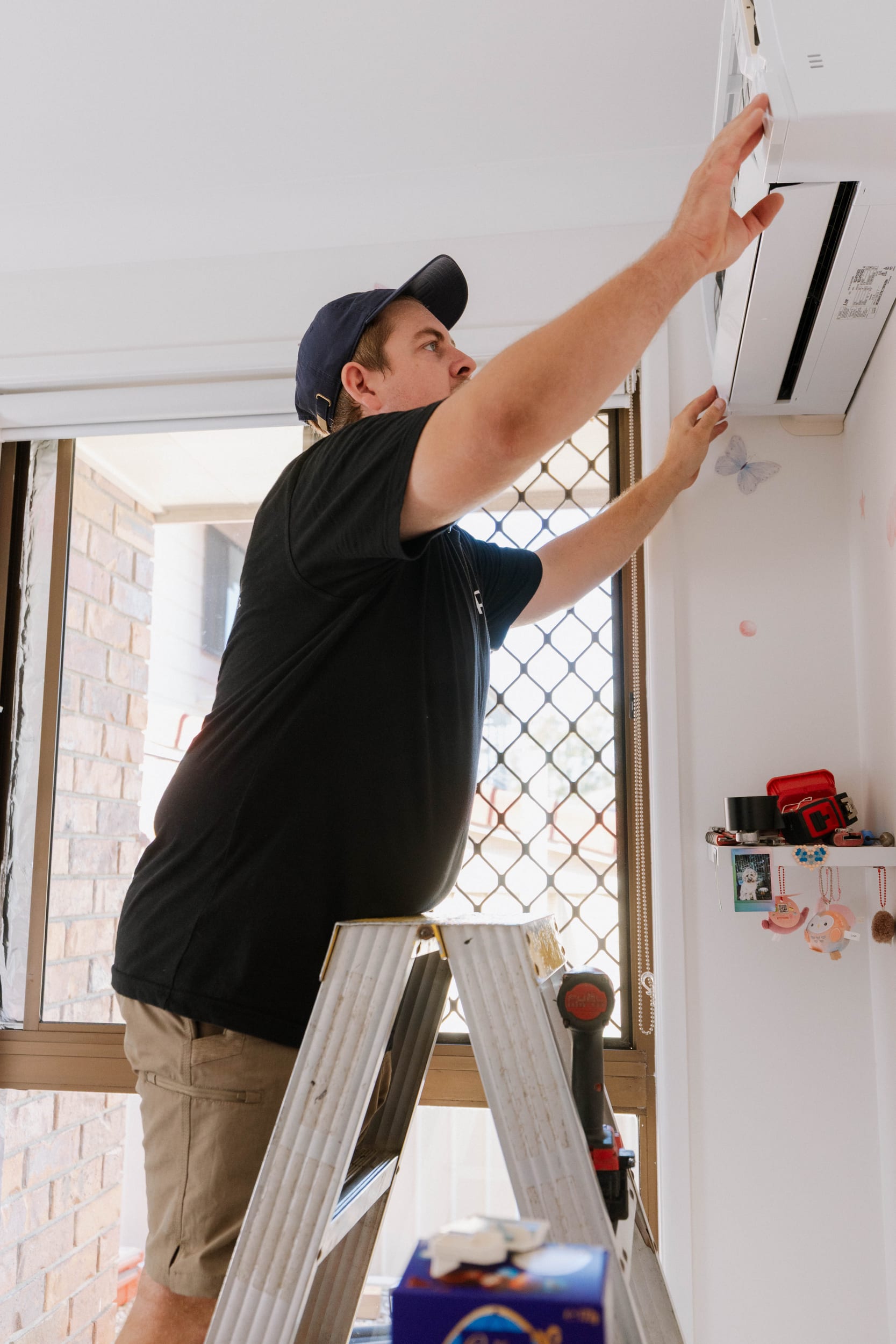 Parker Air technician mounting a Mitsubishi Electric split system head in a McDowall bedroom