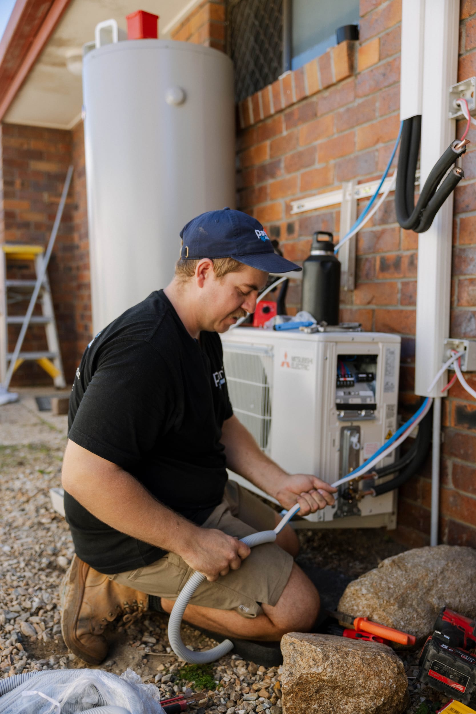 Parker Air technician finishing refrigerant pipework on a Mitsubishi Electric outdoor unit in McDowall