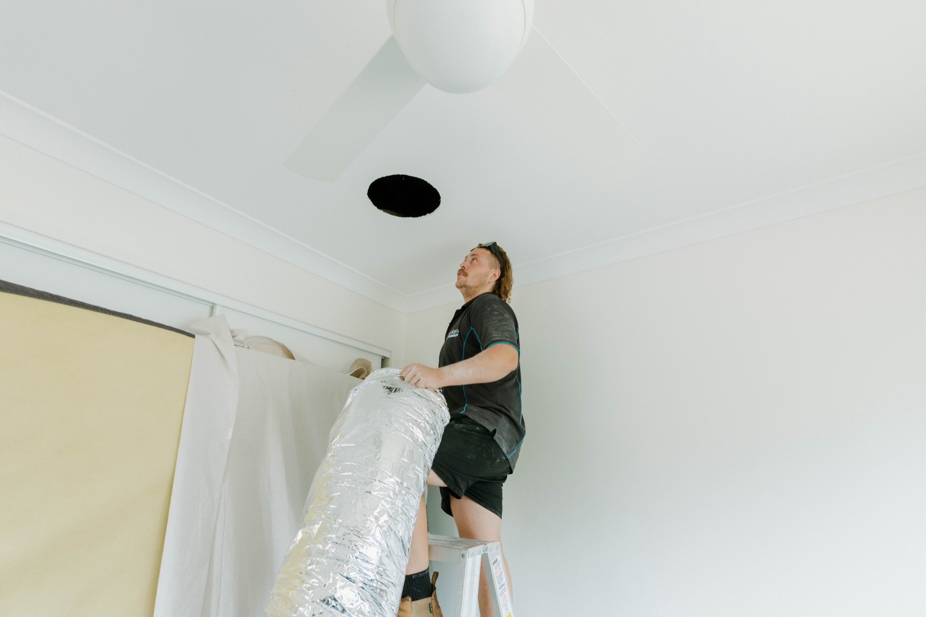 Feeding insulated flexible ductwork through ceiling cavity during ducted aircon install