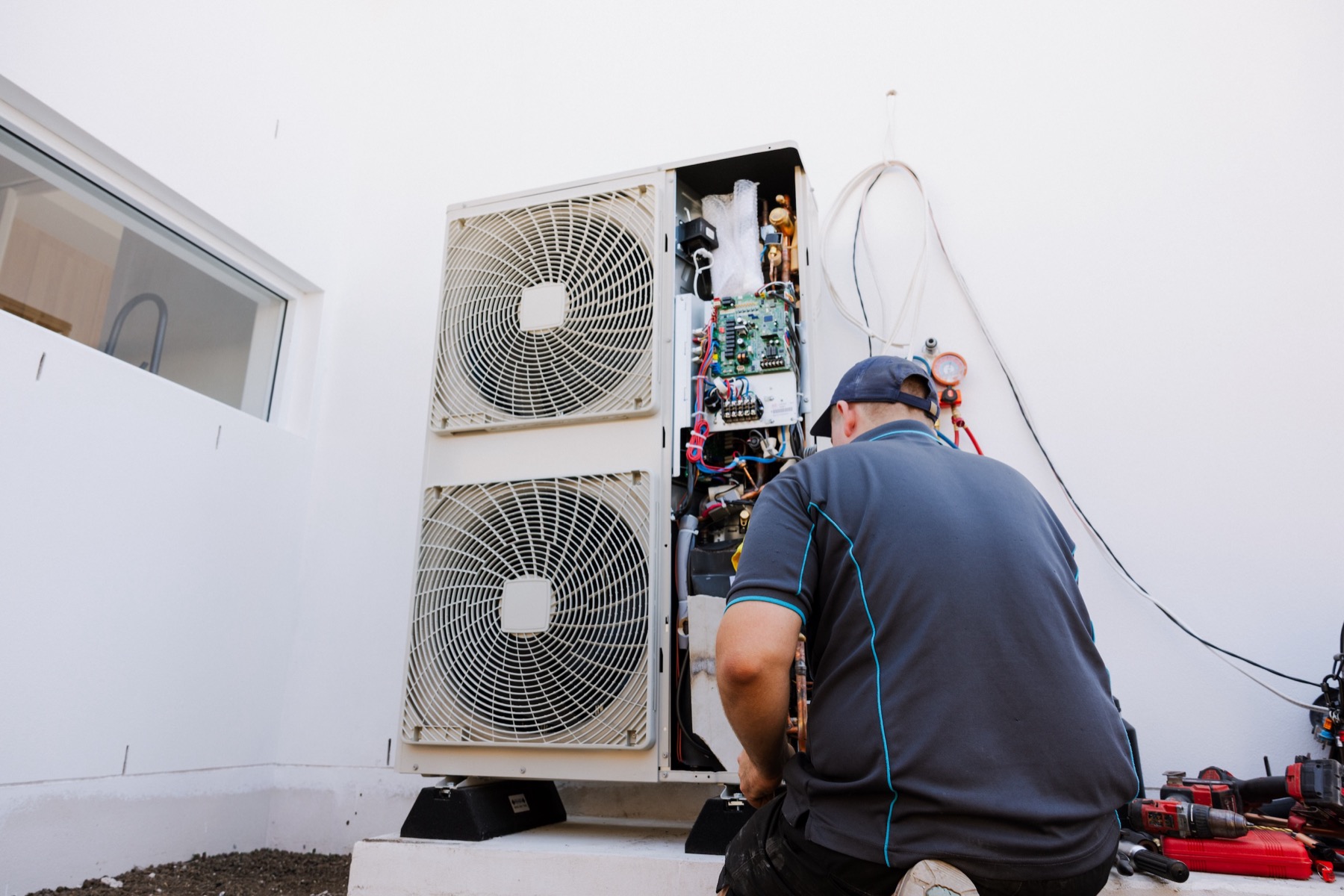 Parker Air Solutions team placing a ducted air conditioning outdoor unit at a residential install